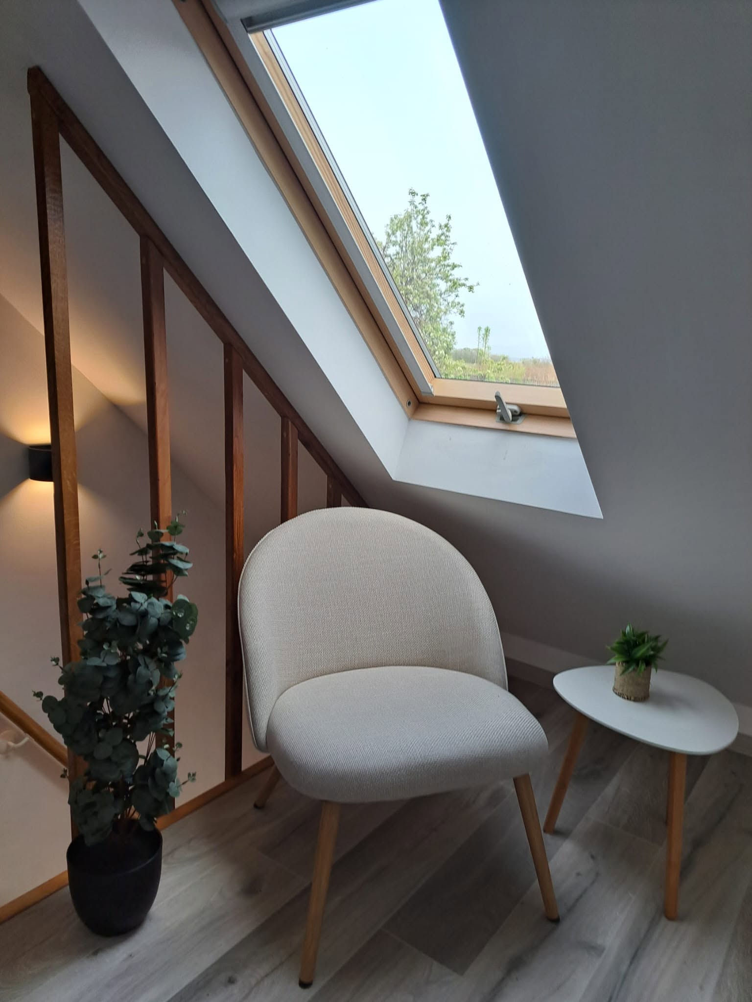 Mirni kutak u potkrovlju Spa House Adrian s krovnim prozorom i pogledom prema zelenilu