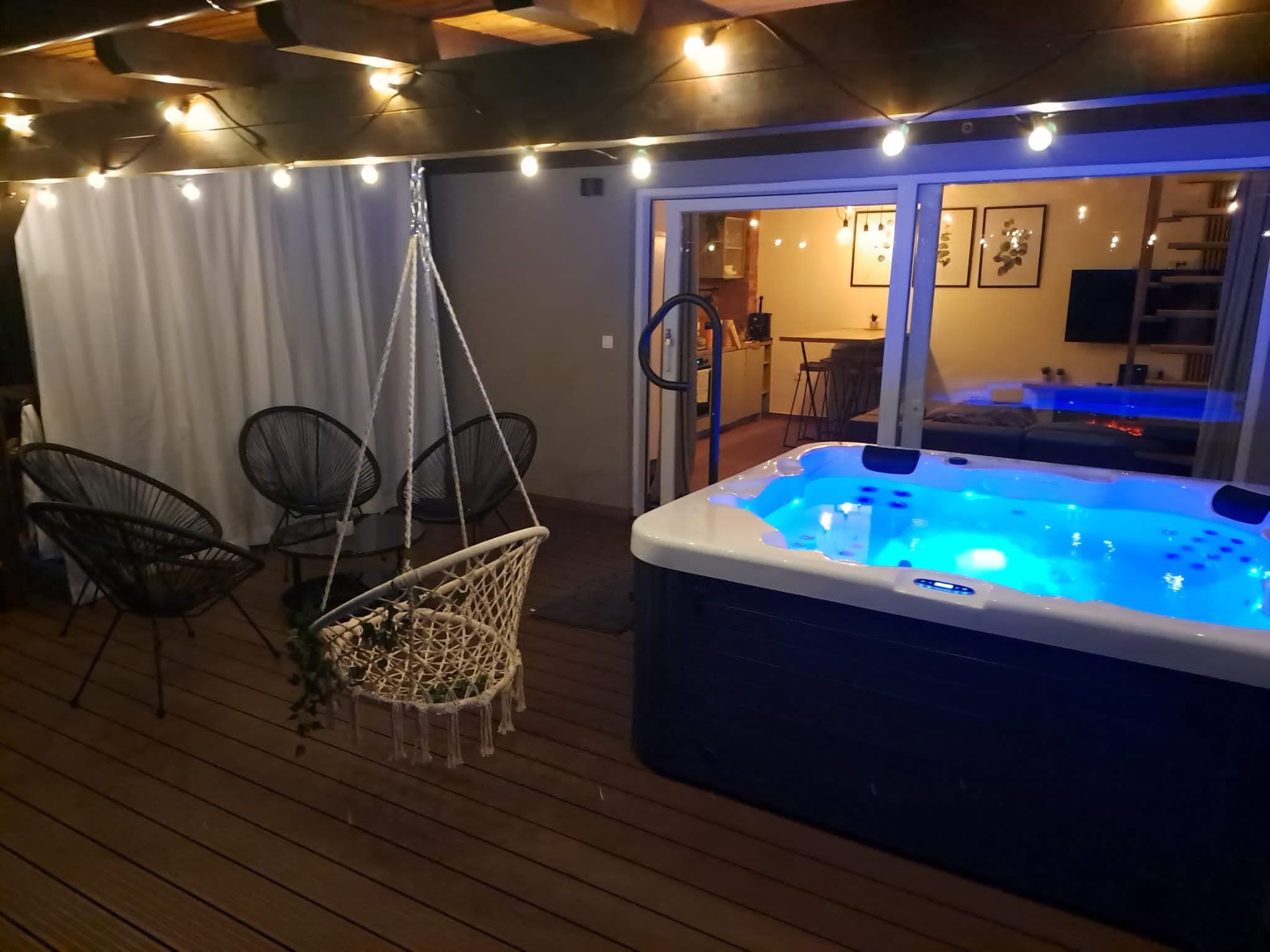 Noćni jacuzzi na terasi s toplim svjetlima